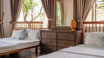 Un dormitorio con dos camas, un aparador de madera y un espejo.