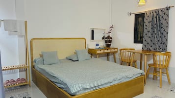 Een slaapkamer met een houten bed, een bureau, een stoel en een kleine tafel.