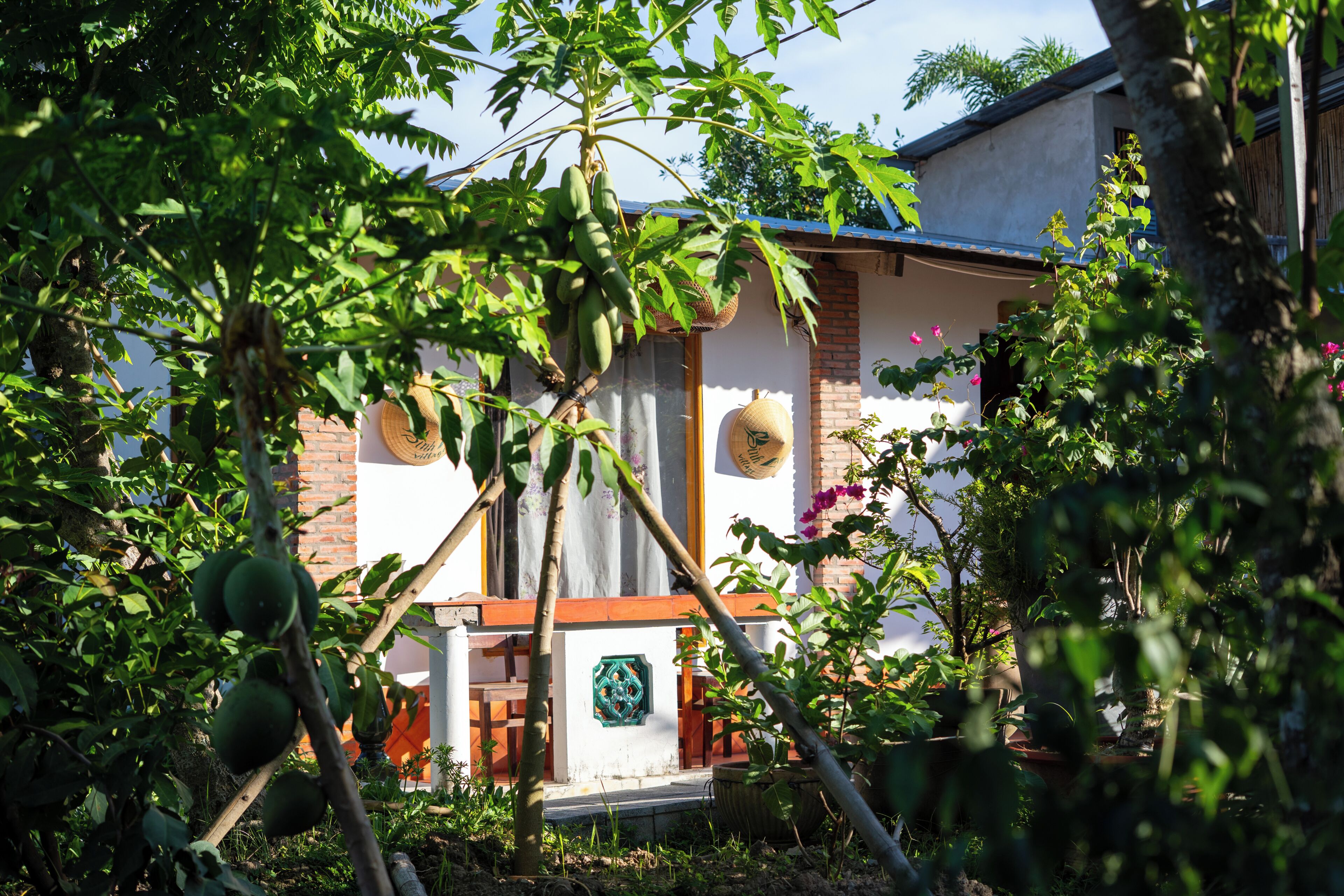 Une maison avec une façade en briques, une porte en bois et un petit porche.