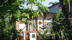 A house with a brick exterior, a wooden door, and a small porch area. - Bình An Village (Phuoc Hau)