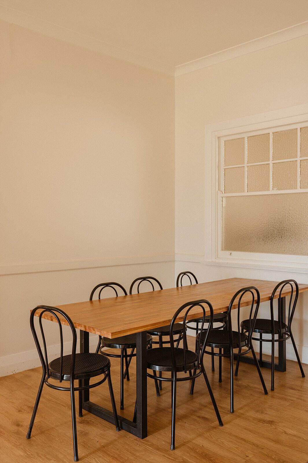 A dining area with a wooden table and six black chairs.