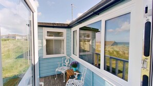 Une chambre avec vue sur la mer, une fenêtre et une petite table avec des chaises.