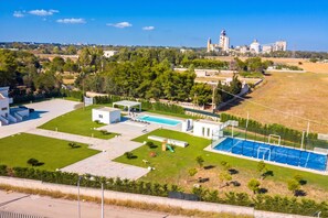 A residential area with a swimming pool, a small building, and a large building in the background.