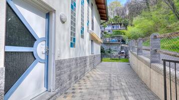 A building with a paved walkway, a door with a blue frame, and a window with a blue tint.