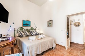 Ein Schlafzimmer mit Bett, Nachttisch, Lampe und Wanddekorationen.