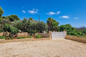 A gated property with a gravel driveway, stone walls, and various shrubs and trees. - Villa Pescoluse with Pool and Sea View, Salve, Italy (Salve)