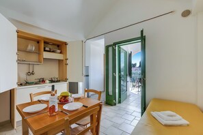 Uma cozinha compacta com uma mesa de jantar, cadeiras e um pequeno espaço para refeições.