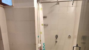 A bathroom with a toilet, shower, and a glass-enclosed shower area. - Blackbird Cottage Bhimtal (Tallital Bhimtal)
