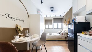 A compact, modern kitchen with a dining area, a bed, and a small kitchenette. - Riveria City KL Sentral by Sleepy Bear (Kuala Lumpur)