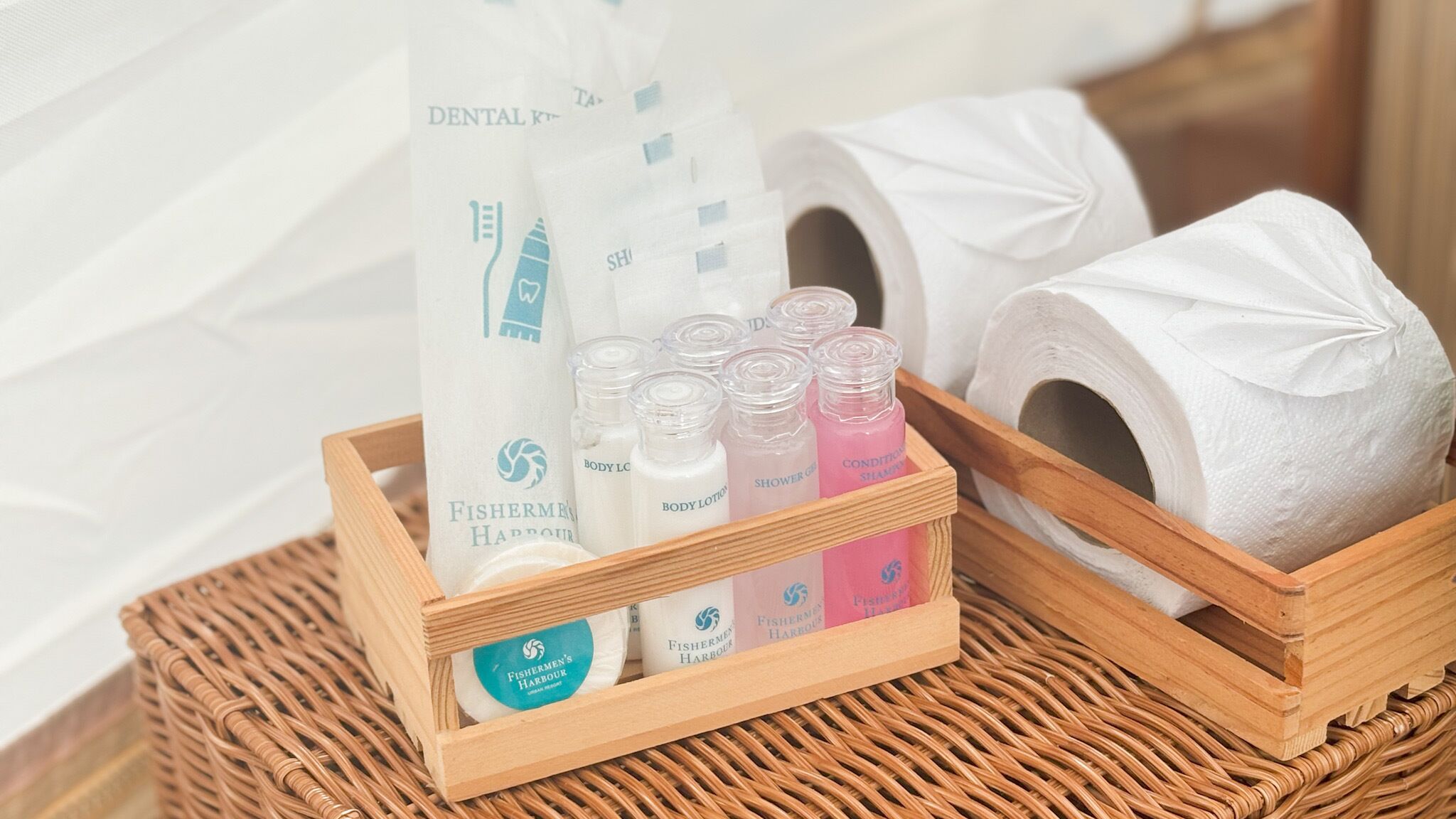 Cestino di legno contenente articoli da toilette come lozione corpo, gel doccia e filo interdentale.