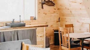 Une pièce confortable de style loft, comprenant un coin repas, un canapé et une cuisine équipée d’un évier et d’un luminaire suspendu.