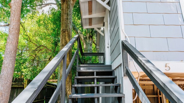 Una scala in legno conduce a una casa con il numero 5.