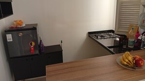 Eine Küche mit Kühlschrank, Herd und einer Holzauslage mit Obst.