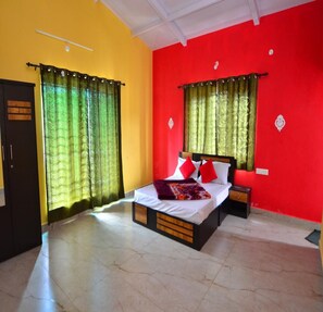 A bedroom with a bed, curtains, a wardrobe, and a nightstand. - Estay Tiger Hills (Ooty)