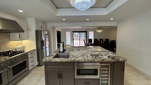 A modern kitchen with granite countertops, stainless steel appliances, and a central island. - Spacious 4300 sq ft Bay Escape – On Golf Course & Near to Beach and Trials (Half Moon Bay)