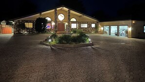 A well-lit building with a stone facade, a covered parking area, and a landscaped garden. - Spacious 4300 sq ft Bay Escape – On Golf Course & Near to Beach and Trials (Half Moon Bay)