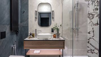 A modern bathroom with a freestanding bathtub, a round mirror, and a wooden vanity.