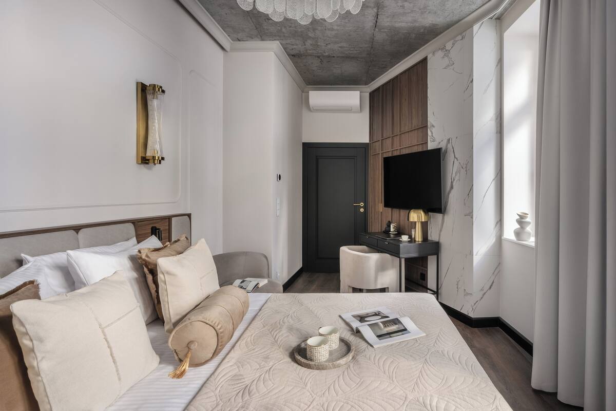 Une chambre d’hôtel moderne équipée d’un lit, d’un bureau, d’une télévision et d’une porte de salle de bain.
