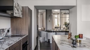 Une cuisine moderne dotée de plans de travail en marbre, de meubles en bois et d’un îlot central avec des sièges.