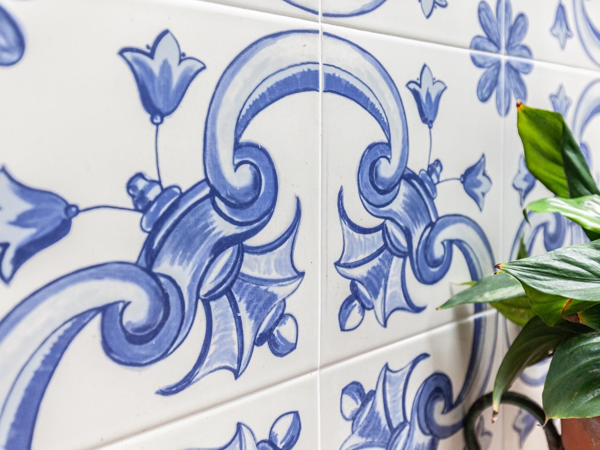 A close-up of a tiled wall with blue floral patterns.