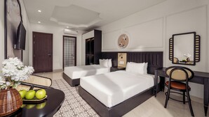 Une chambre d’hôtel avec deux lits, un bureau, une chaise, une télévision et un élément décoratif mural.