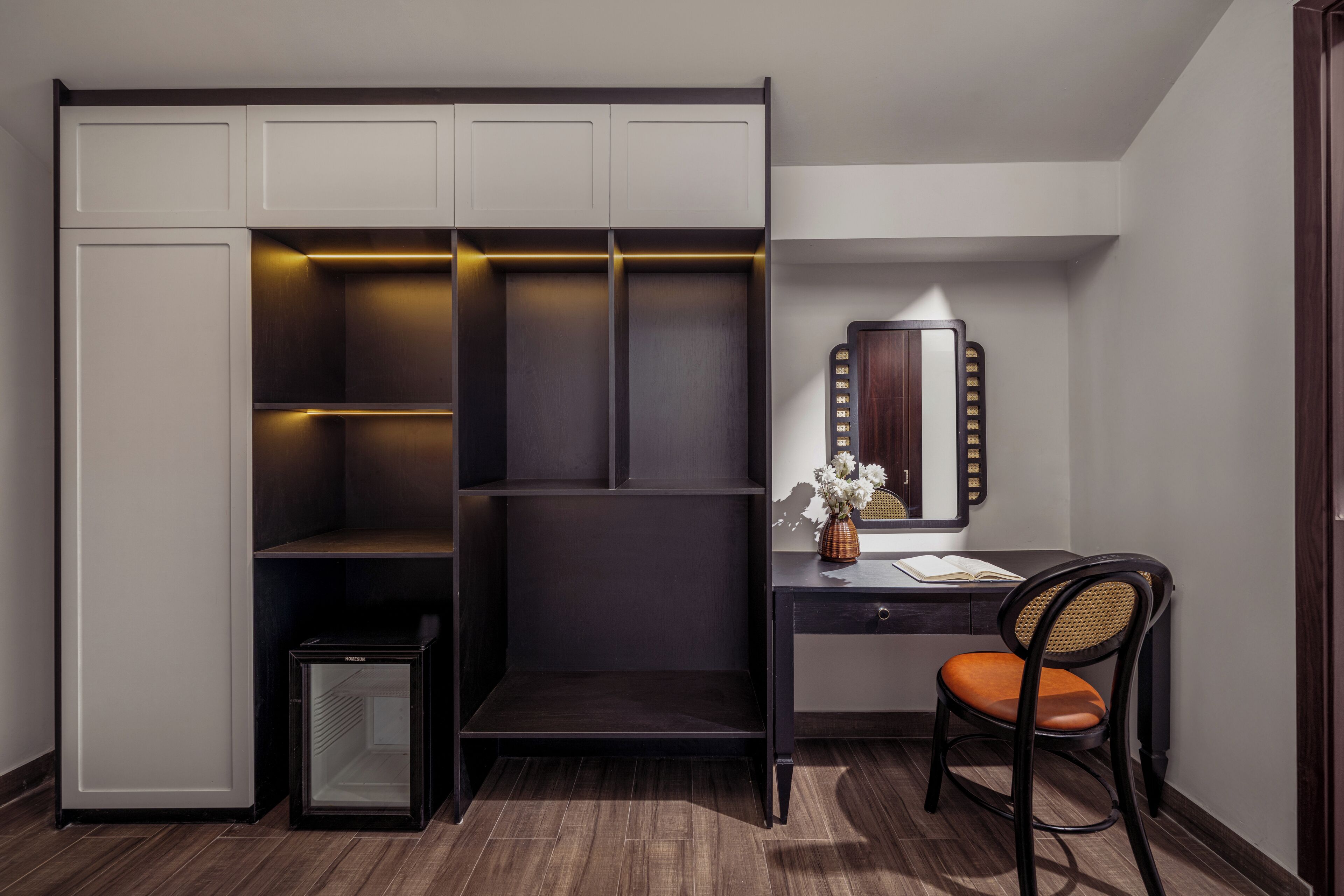 Ein kleines Schlafzimmer mit integriertem Kleiderschrank, einem kleinen Nachttisch und einem Stuhl.