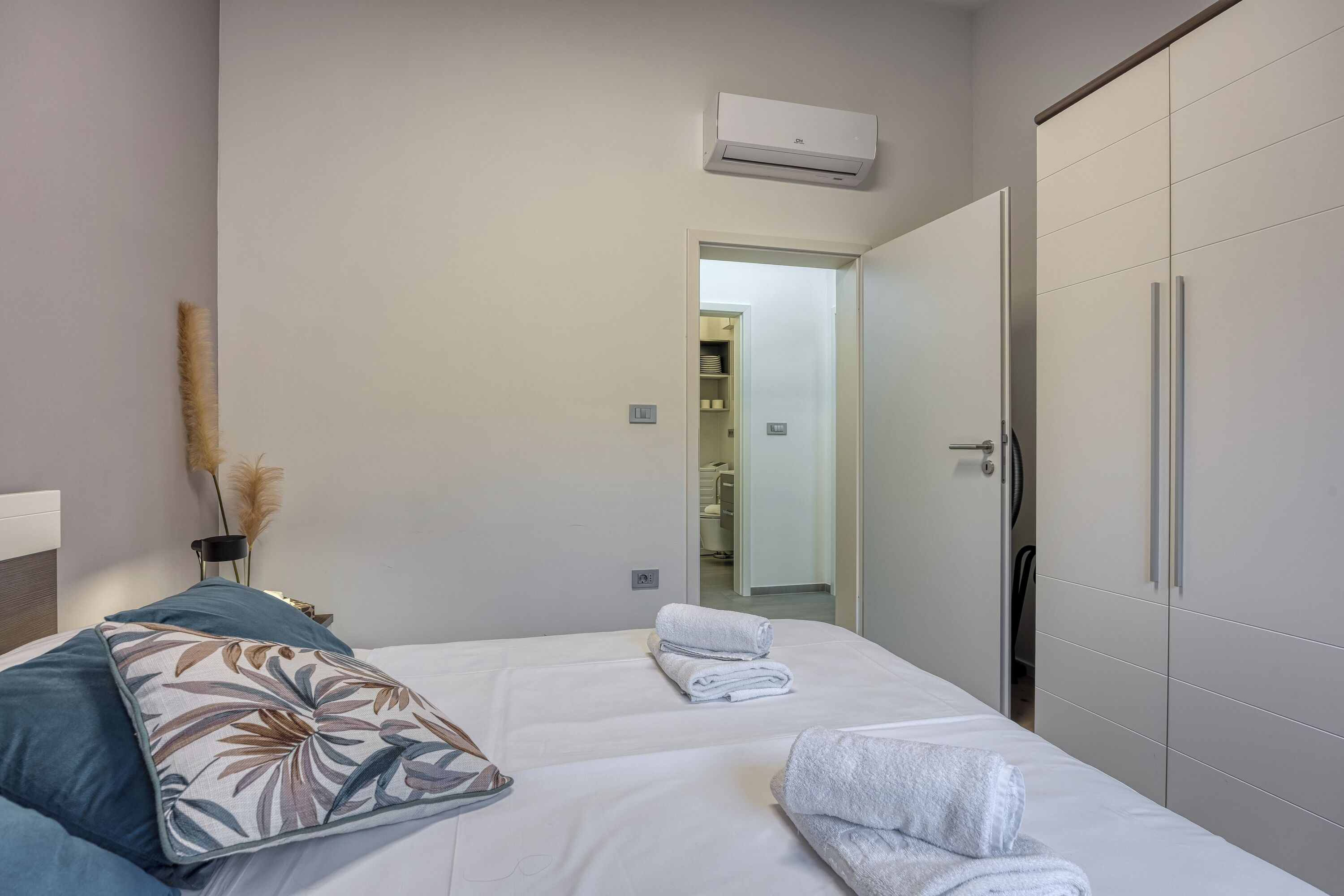 Een hotelkamer met een bed, een kledingkast en een airconditioner.
