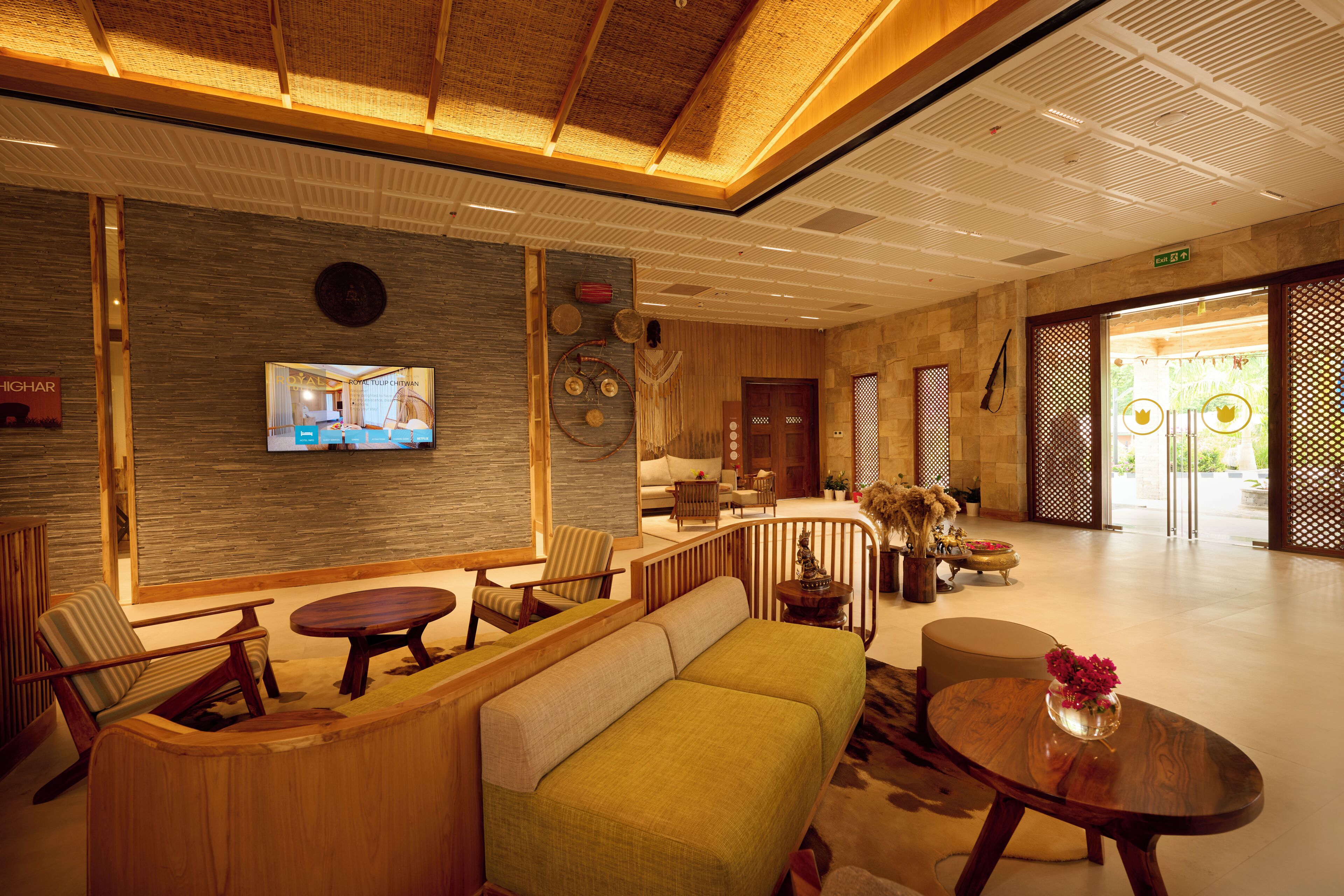 A spacious lobby with a reception desk, seating area, and a television mounted on the wall.