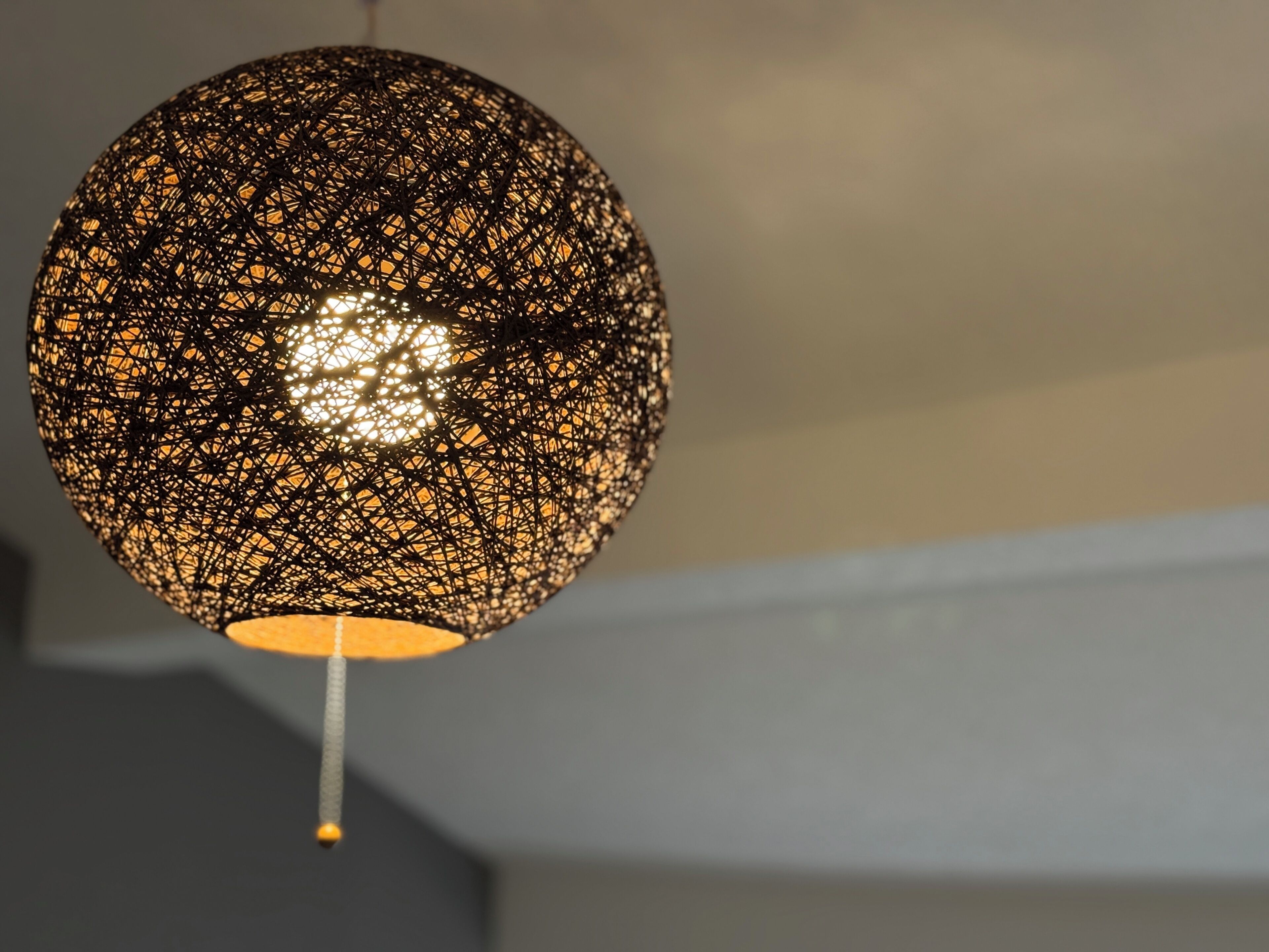 A spherical hanging light fixture with a geometric pattern.
