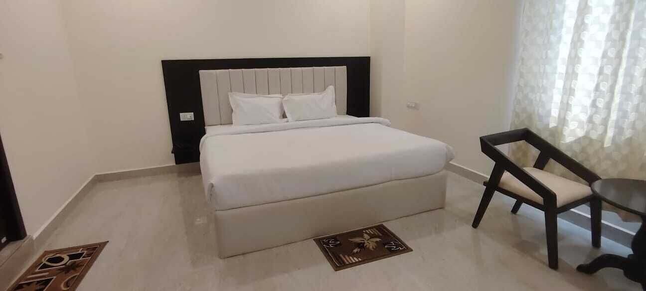 A bedroom with a bed, a chair, and a small table.