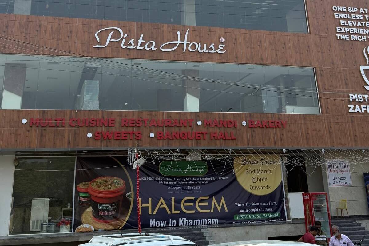A building with a sign for 'Hotel Taba' and 'Pista House' on the ground floor.