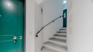 Eine Treppe mit Geländer führt zu einer Tür mit Schlüsselloch.