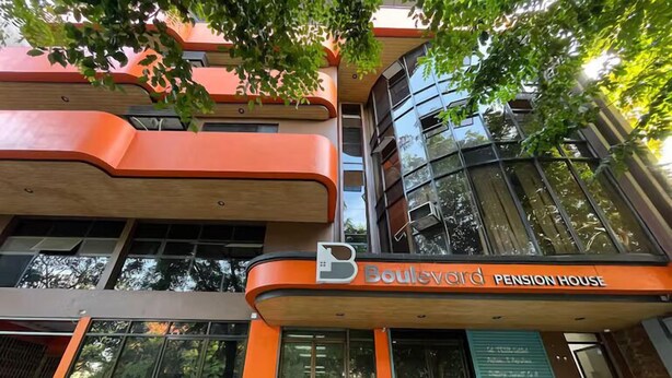 A multi-story building with a prominent orange facade and large windows. The sign reads "Boulevard Pension House." - Boulevard Pension Hotel powered by Cocotel (Cebu City)