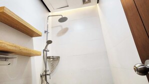 A shower with a handheld showerhead, a wall-mounted control panel, and a wooden shelf above the toilet. - Boulevard Pension Hotel powered by Cocotel (Cebu City)