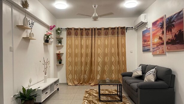 A living room with a sofa, a coffee table, a TV stand, and a patterned rug. - Spacious 3-bedroom apartment with WiFi, AC in charming Phase 02 (Malé)