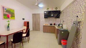 A compact kitchen with a dining area, a small refrigerator, and a trash bin. - Spacious 3-bedroom apartment with WiFi, AC in charming Phase 02 (Malé)