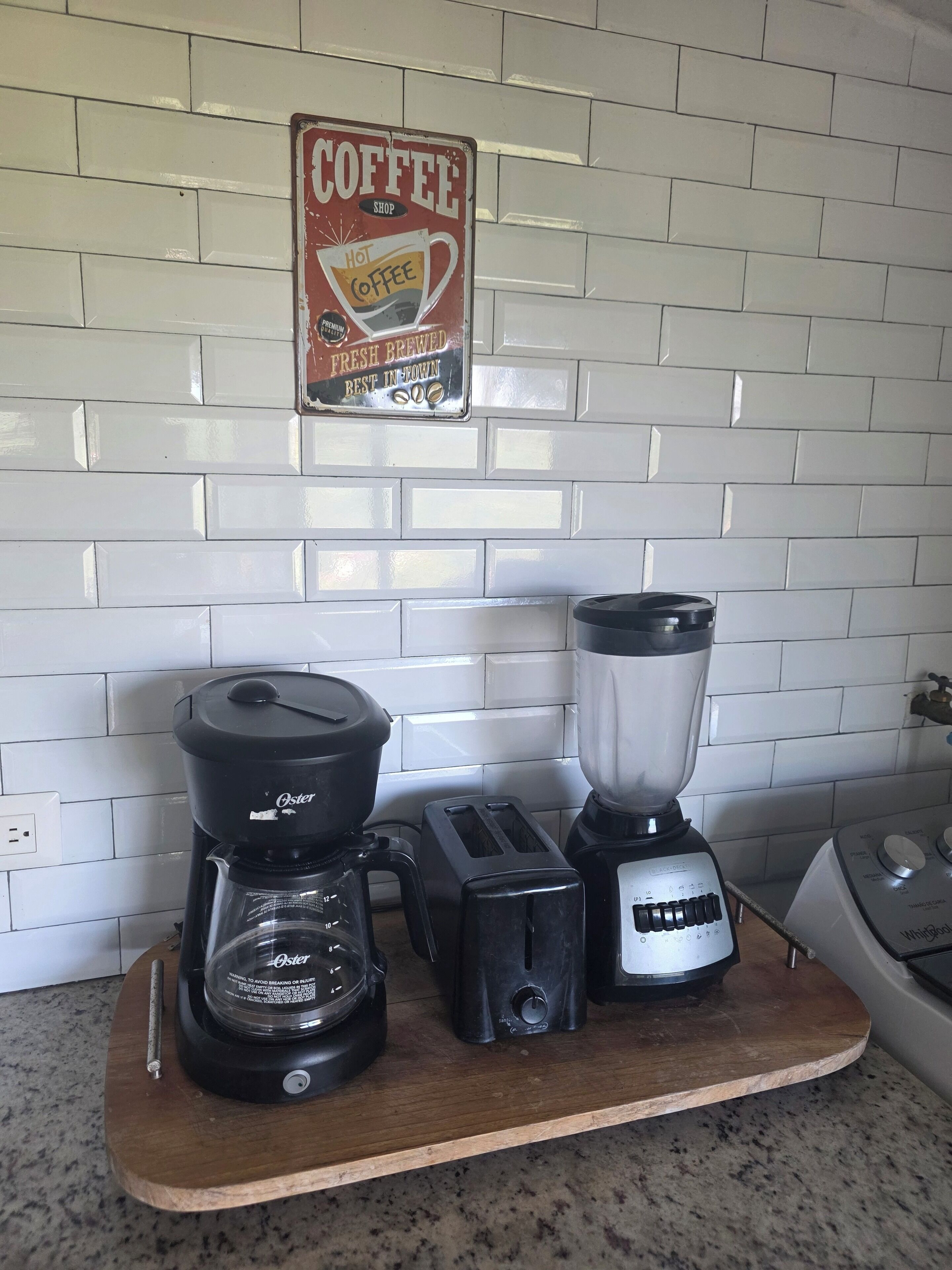 Una encimera de cocina con cafetera, tostadora y licuadora.