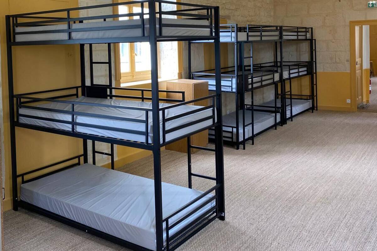 Bunk beds in a room with stone walls and a carpeted floor.