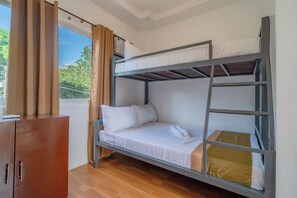 A bunk bed with white bedding, a wooden wardrobe, and a window with curtains. - Upgrace Inn Coron (Coron)