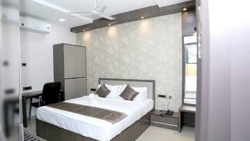 Una habitación de hotel moderna con una cama grande, un escritorio y un armario.