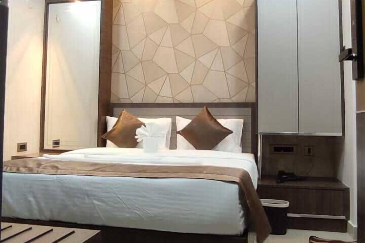A modern bedroom with a large bed, a wardrobe, and a television.