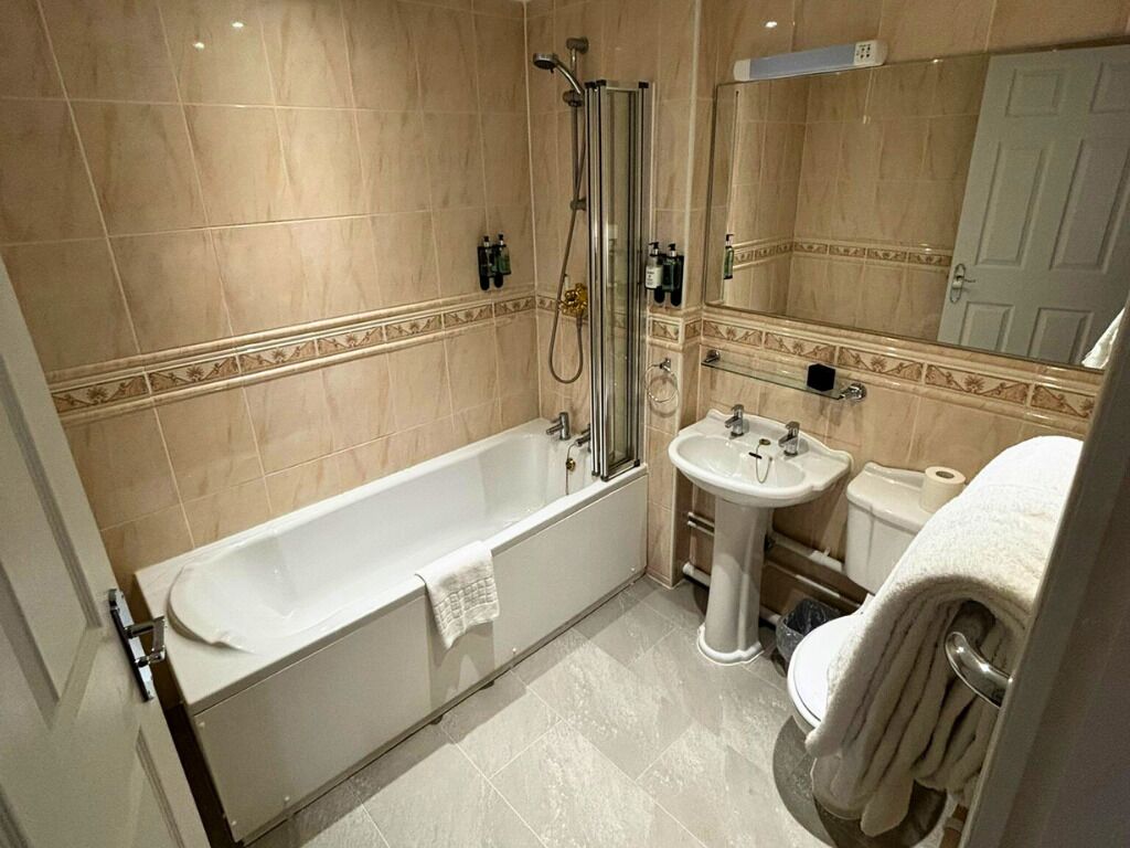 Un bagno con una vasca, un lavandino e una doccia.