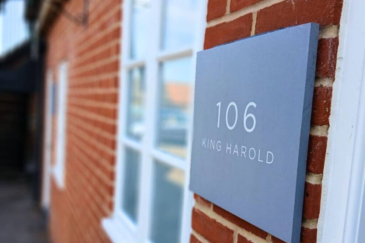A house number sign on a brick wall.
