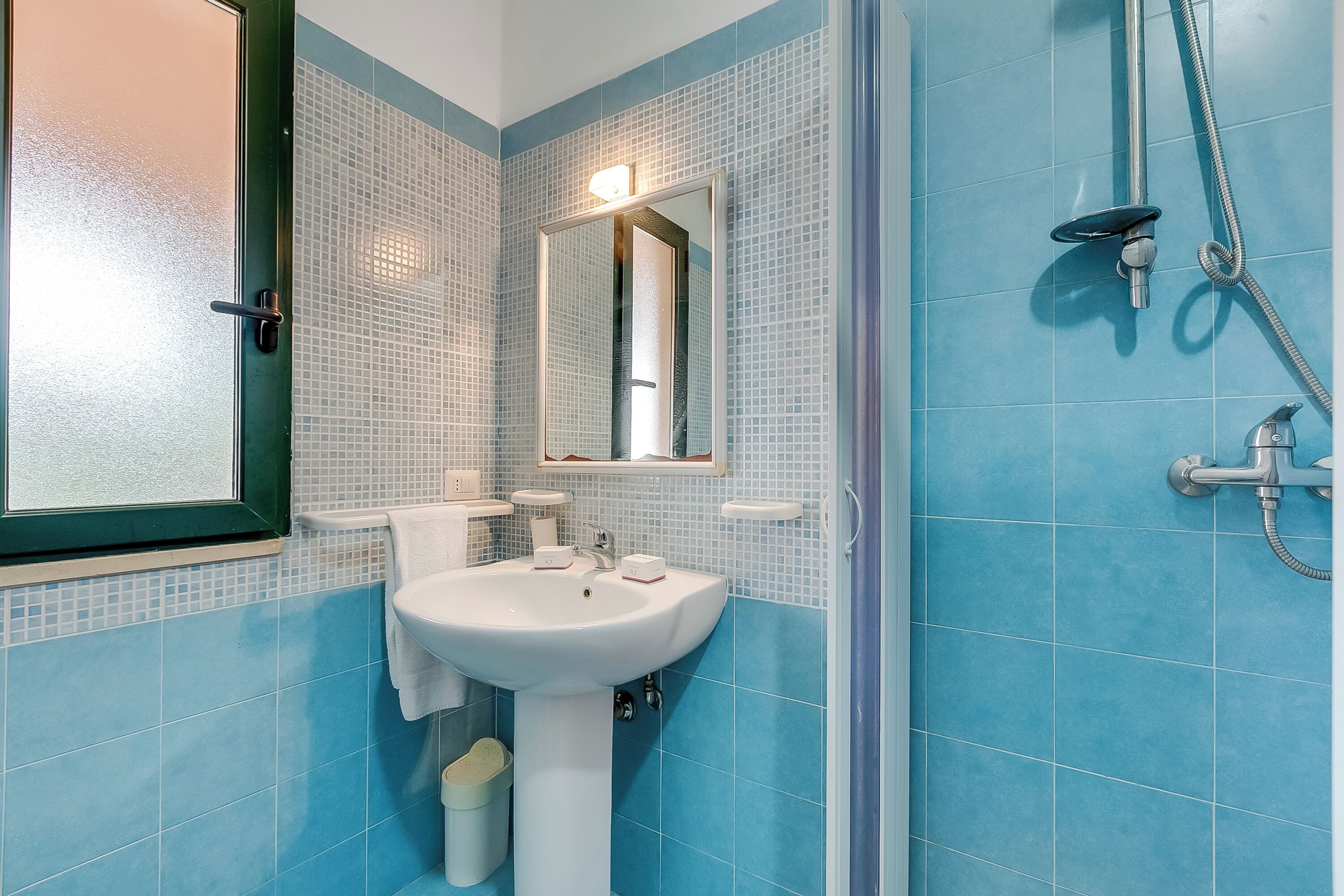 Un baño con lavamanos, espejo y ducha.