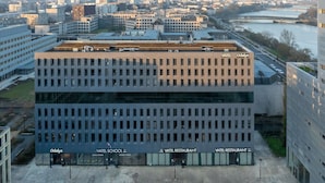 Un edificio moderno con varios pisos, identificado como 'VATEL SCHOOL' y 'VATEL RESTAURANT'.