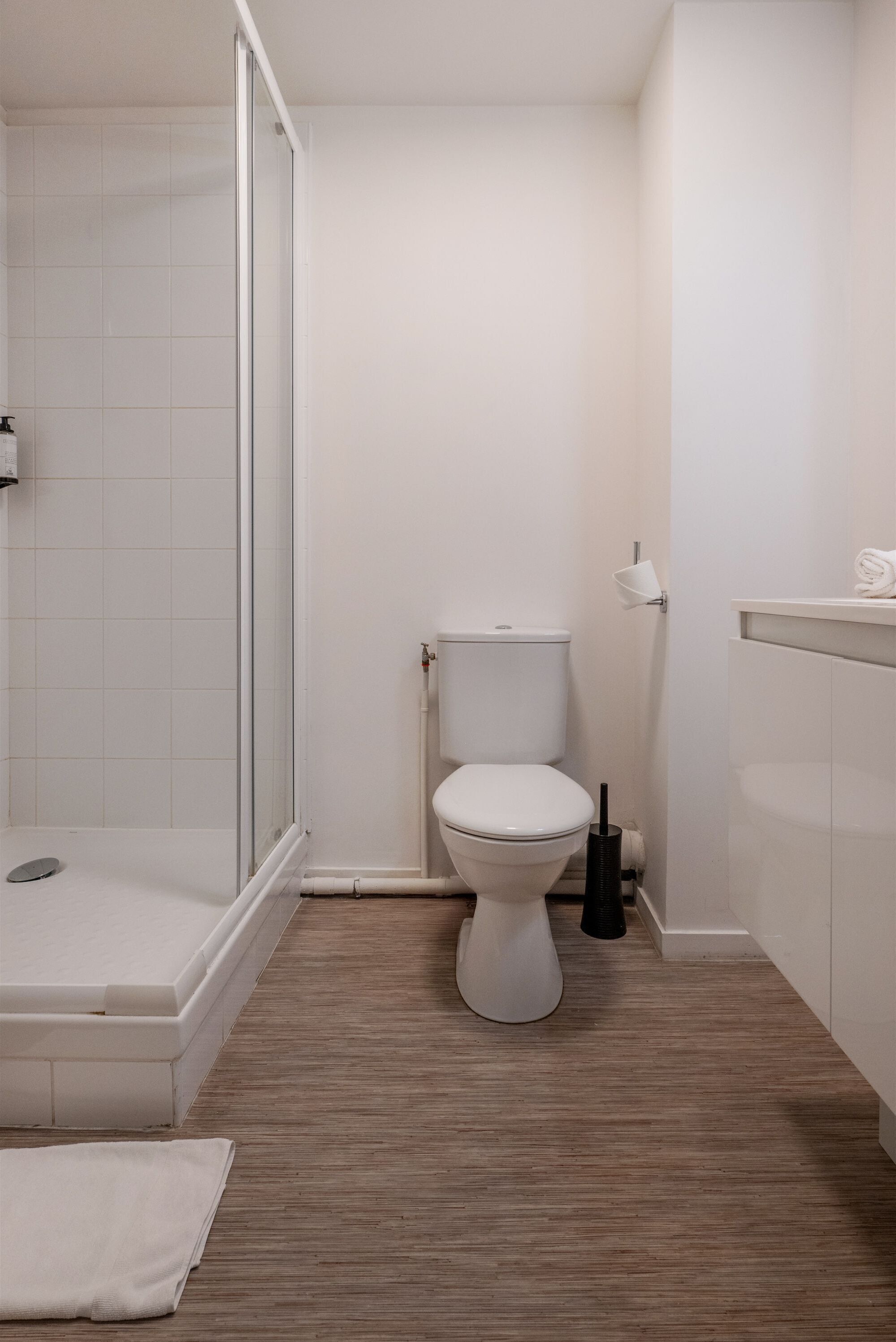 A modern bathroom with a toilet, shower, and sink.