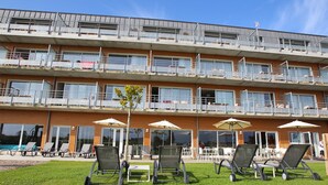Un hotel de varios pisos con terraza al aire libre y piscina.
