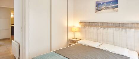 Sleep in the double bed, with a bedside lamp next to it and sliding wardrobe doors in the background