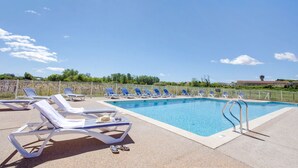 A swimming pool with lounge chairs and a fenced area. - Maison Cosy + Piscine Extérieure Chauffée (Colombiers)