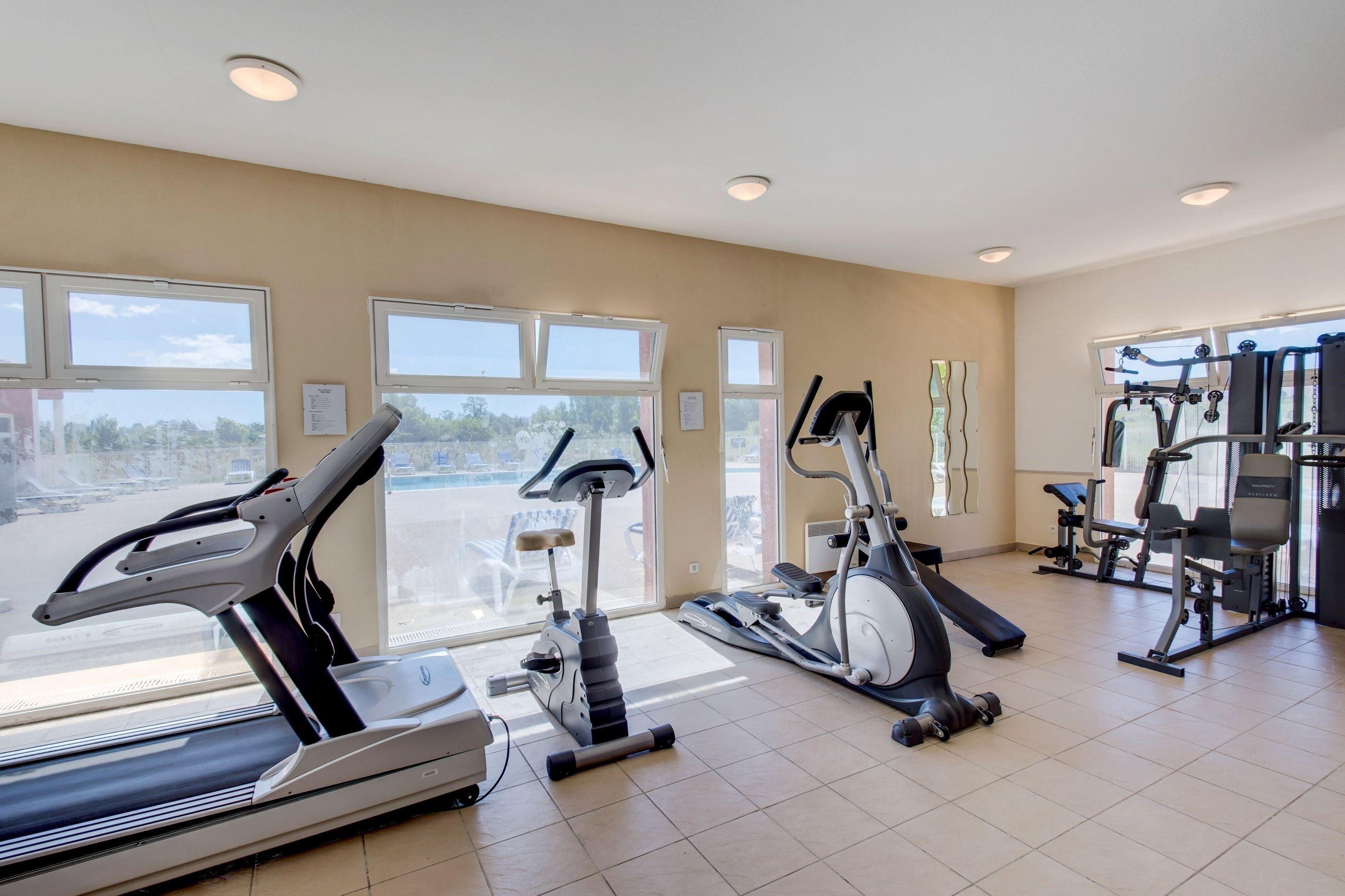 A gym with treadmills, elliptical machines, and weight equipment.